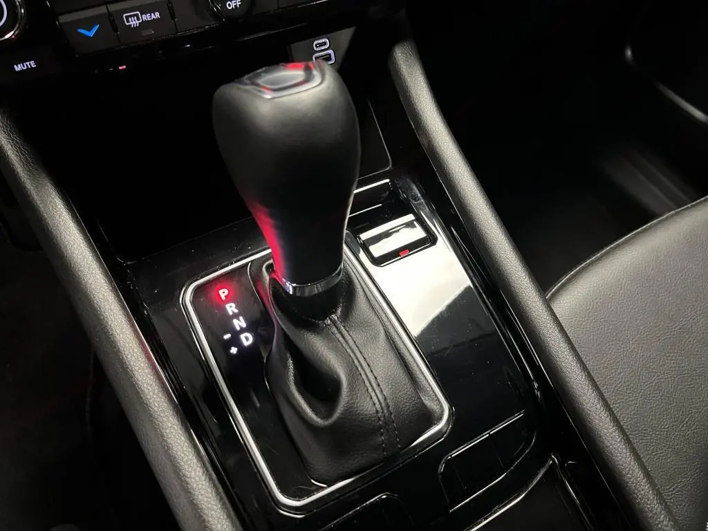 Gros plan sur le levier de vitesses automatique noir brillant de la Jeep Compass 2024, avec indication P allumée en rouge.
