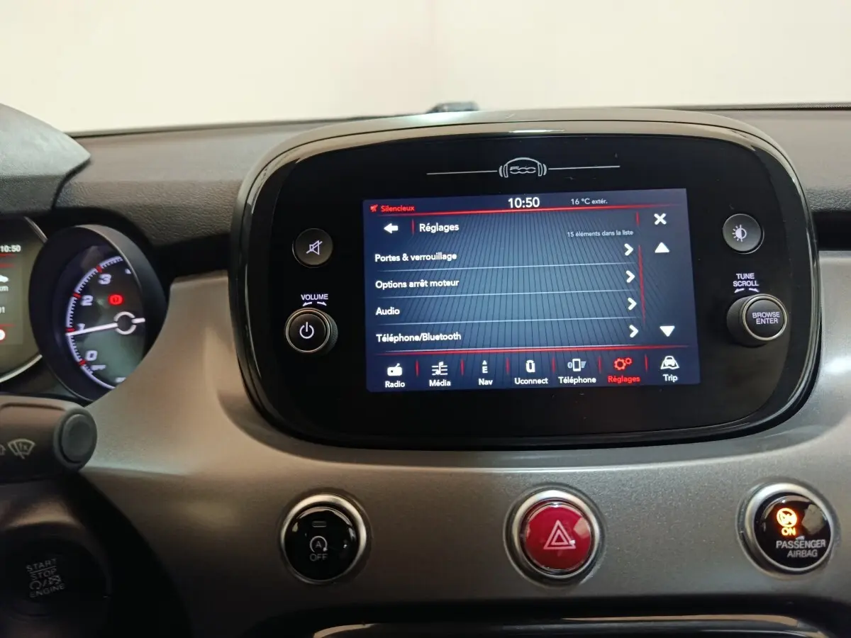Vue rapprochée du tableau de bord gris avec écran tactile central affichant le menu réglages sur FIAT 500X noir.