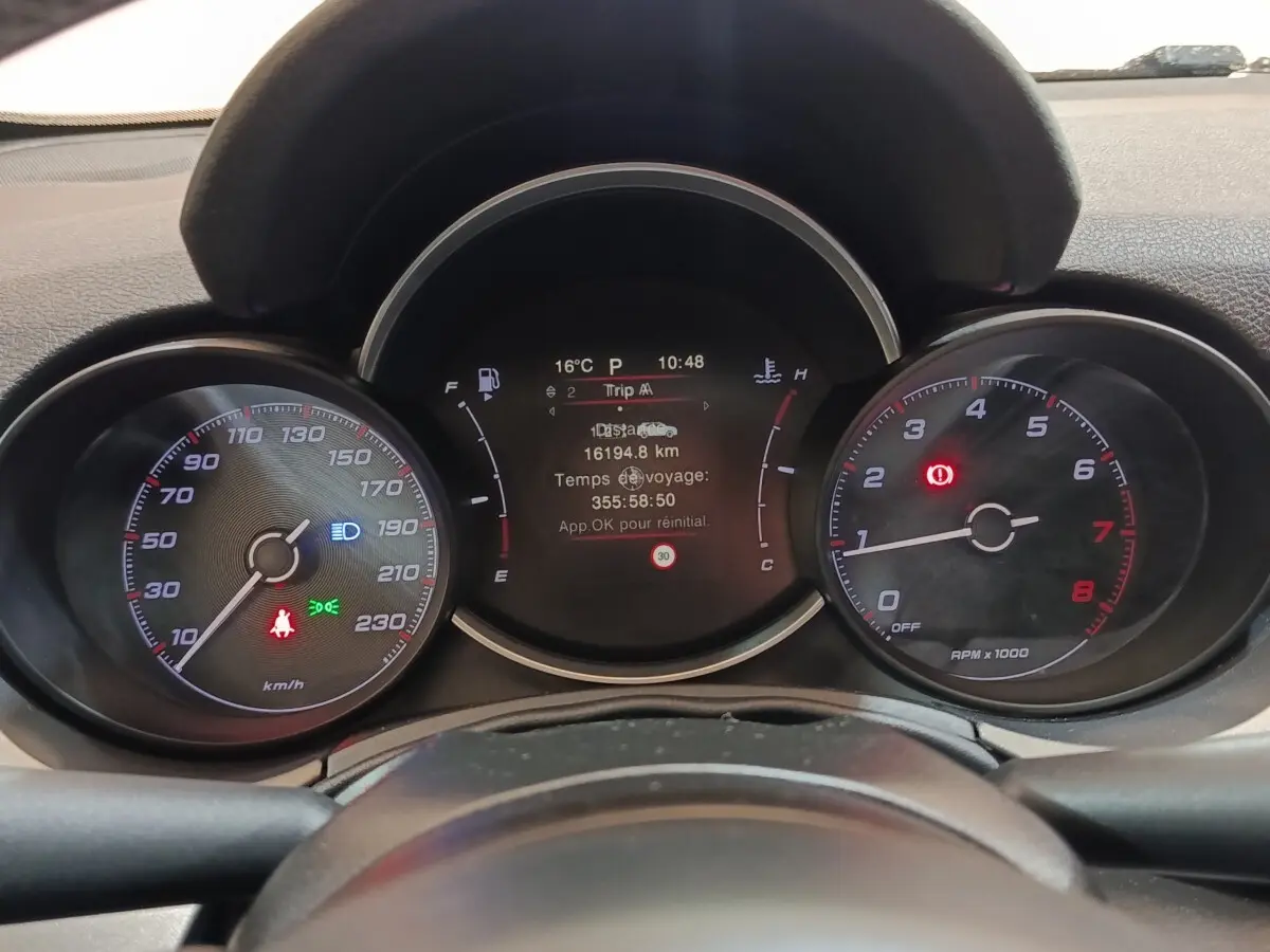 Vue rapprochée du tableau de bord de la Fiat 500X noir, affichant les compteurs et l'écran digital central.