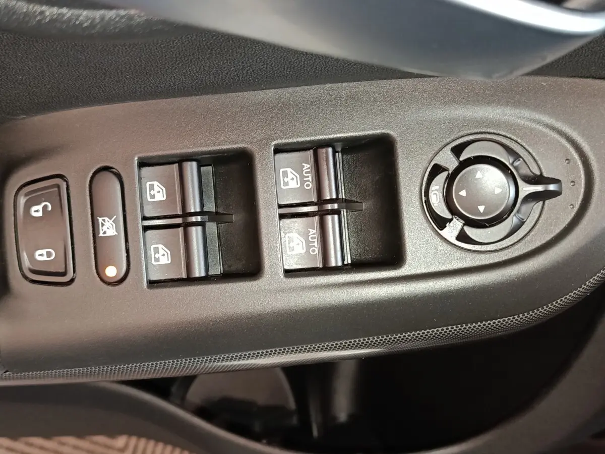 Vue rapprochée des commandes de lève-vitres et réglage des rétroviseurs côté conducteur d'une FIAT 500X noire.