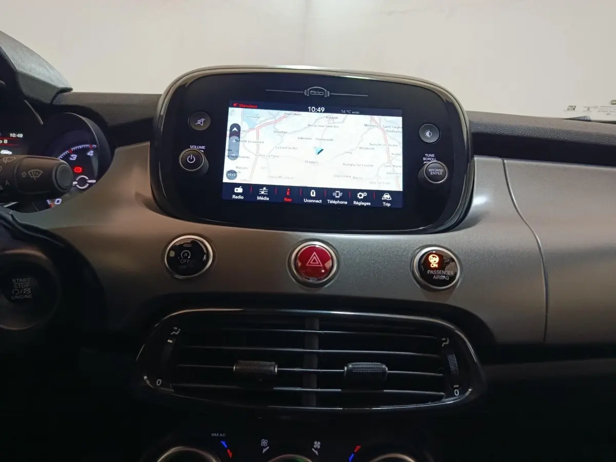 Tableau de bord de Fiat 500X noir avec écran tactile central affichant la navigation, boutons de commande et aérateurs.