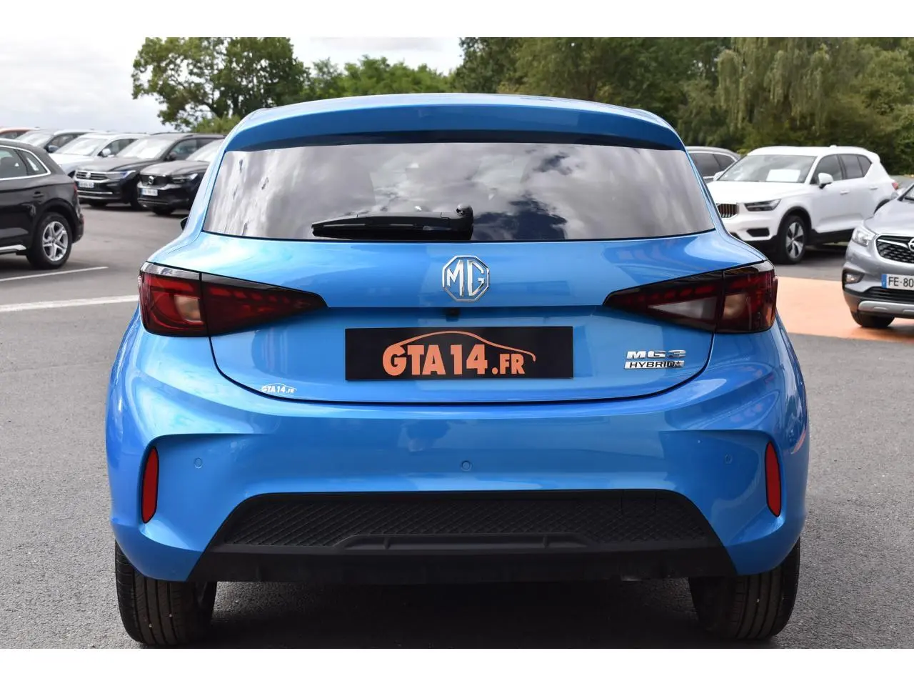 Vue arrière d'une MG3 1.5 Hybrid+ 195 Luxury bleue métallisée avec feux arrière LED et lunette surteintée.