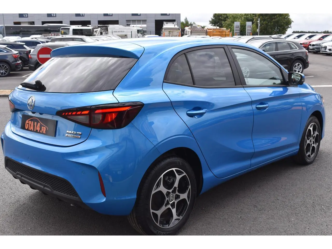 Vue 3/4 arrière droite d'une MG3 1.5 Hybrid+ 195 Luxury bleu métallisé avec jantes alliage 16 pouces et vitres surteintées.