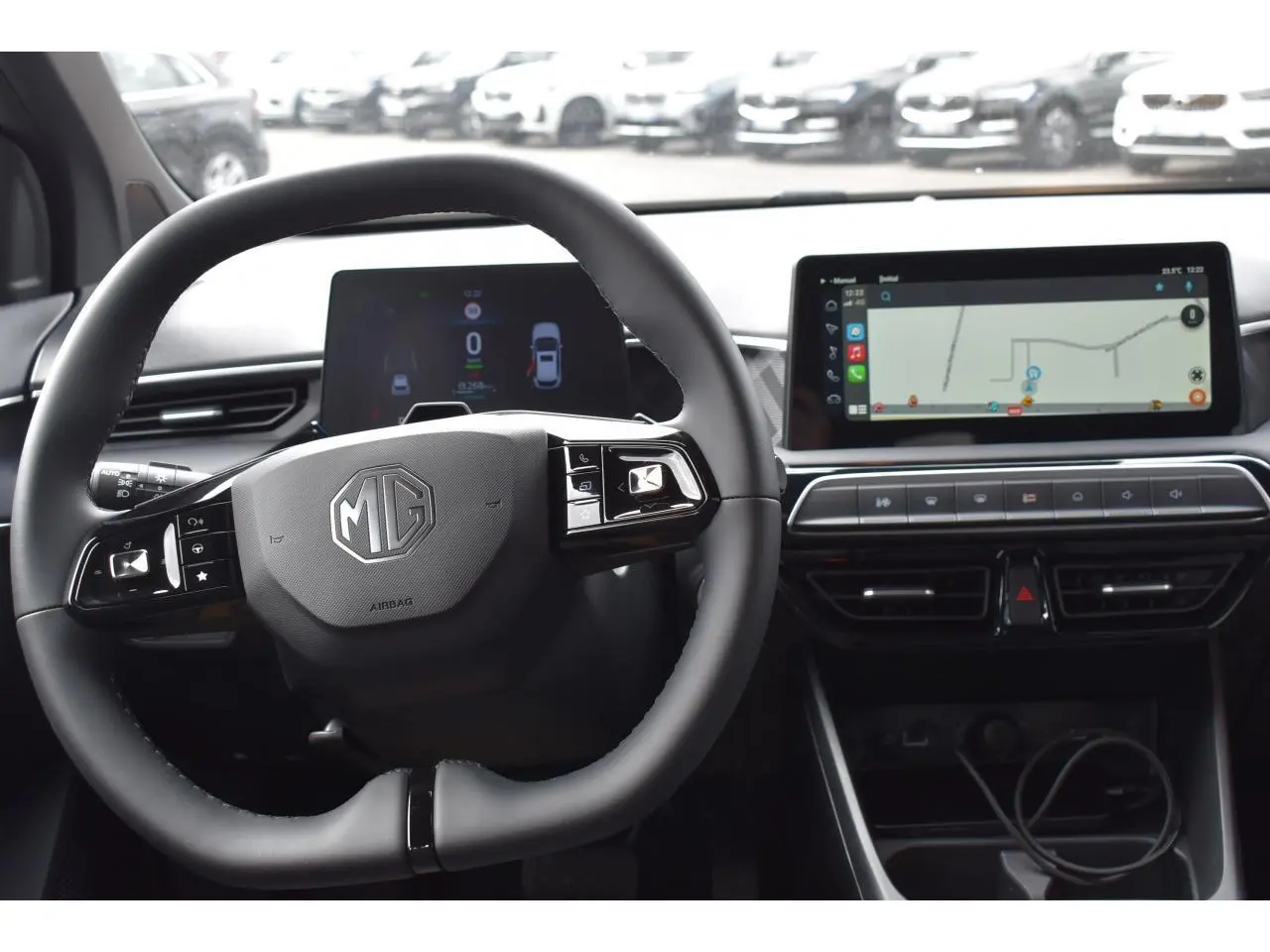 Vue intérieure centrée sur le volant MG et le tableau de bord numérique avec écran tactile affichant la navigation.