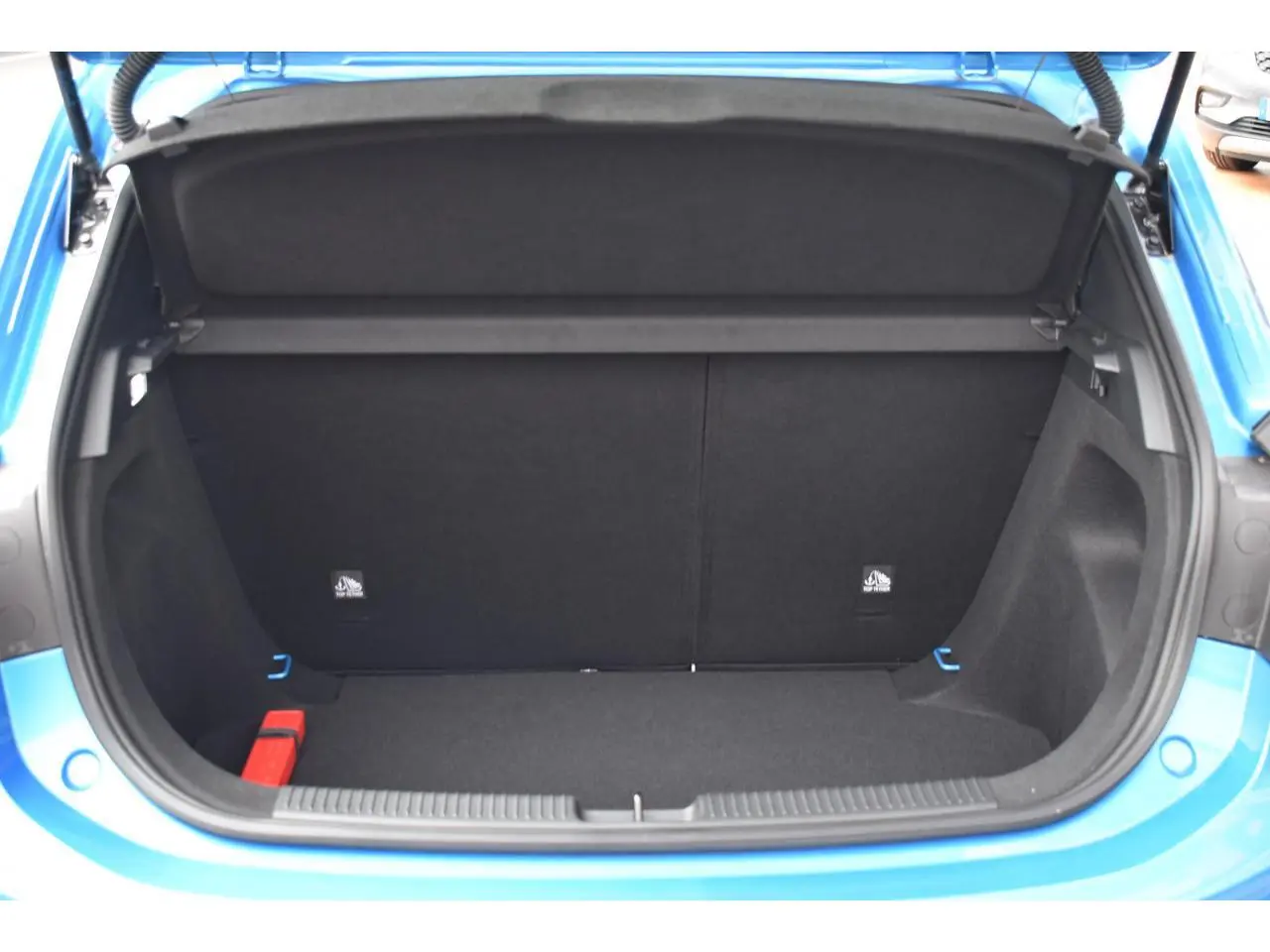 Coffre ouvert d’une MG3 1.5 HYBRID+ 195 LUXURY bleu, vue arrière centrée montrant l’espace de chargement vide.