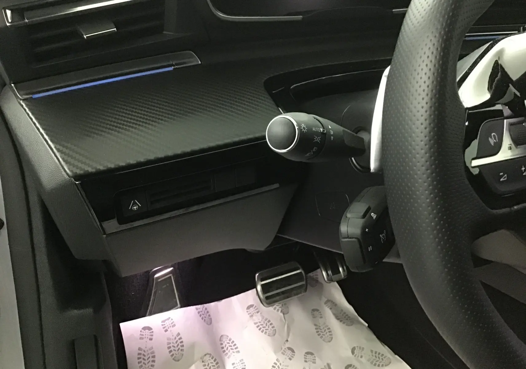 Vue rapprochée côté gauche du poste de conduite du Peugeot 508 SW gris Artense, avec volant perforé et commandes au volant visibles.