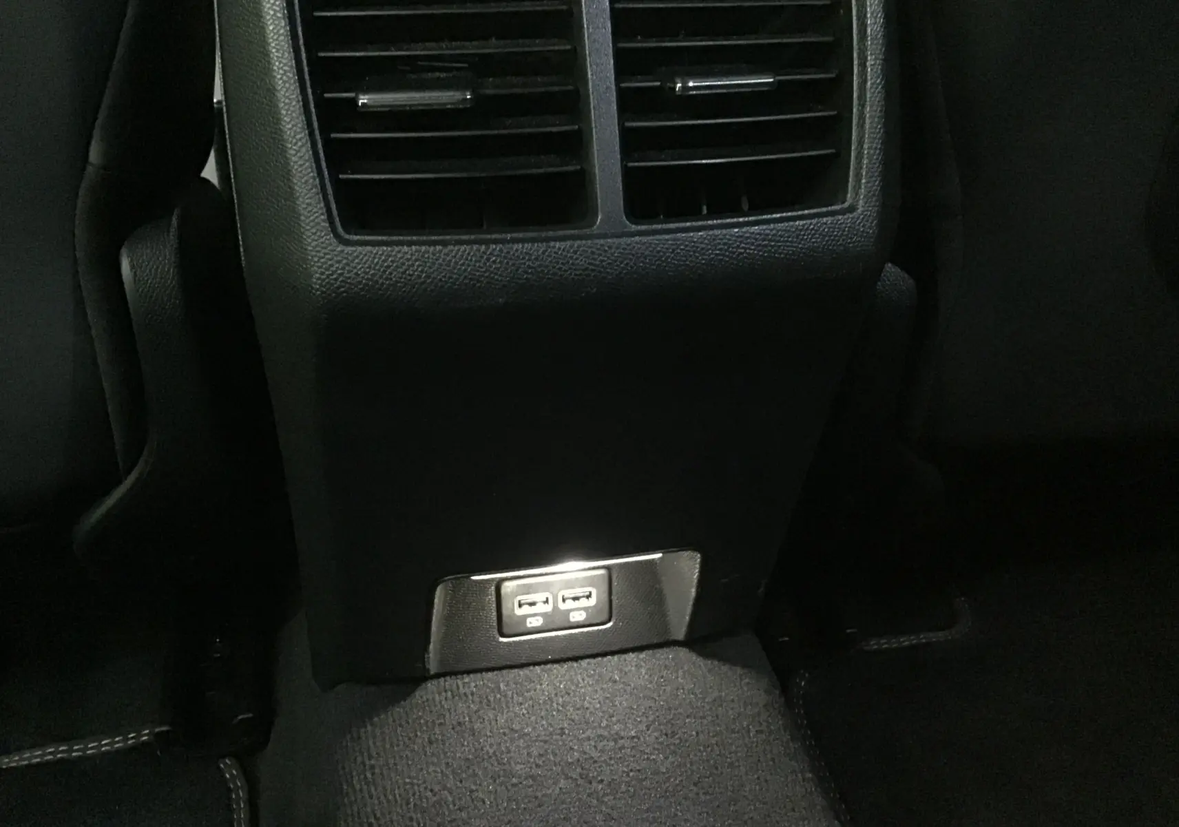 Prise USB double au bas de la console centrale arrière du Peugeot 508 SW gris Artense, intérieur sombre.