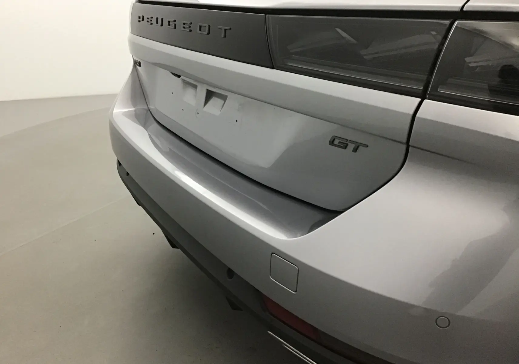 Vue rapprochée du coffre arrière droit gris Artense d'une Peugeot 508 SW GT avec logo et feux sombres.