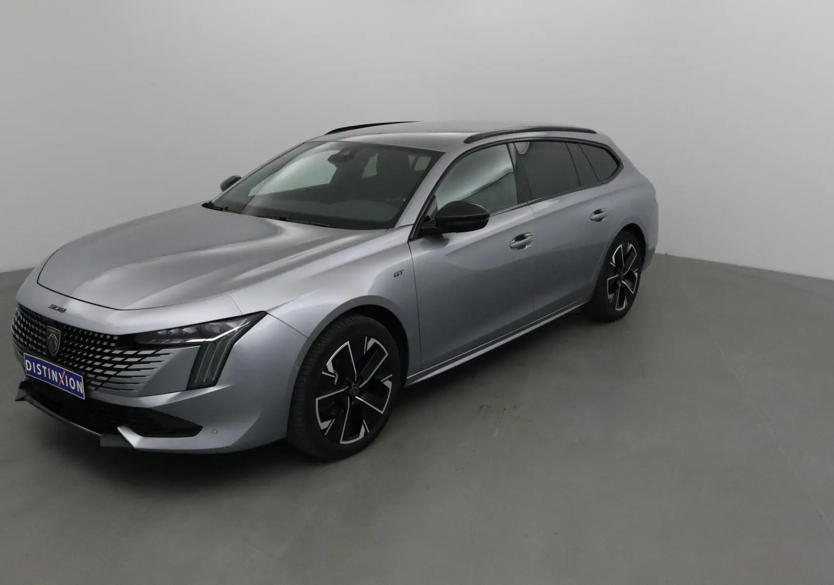 Peugeot 508 SW gris Artense vue 3/4 avant droit, avec jantes noires et phares Full LED distinctifs.