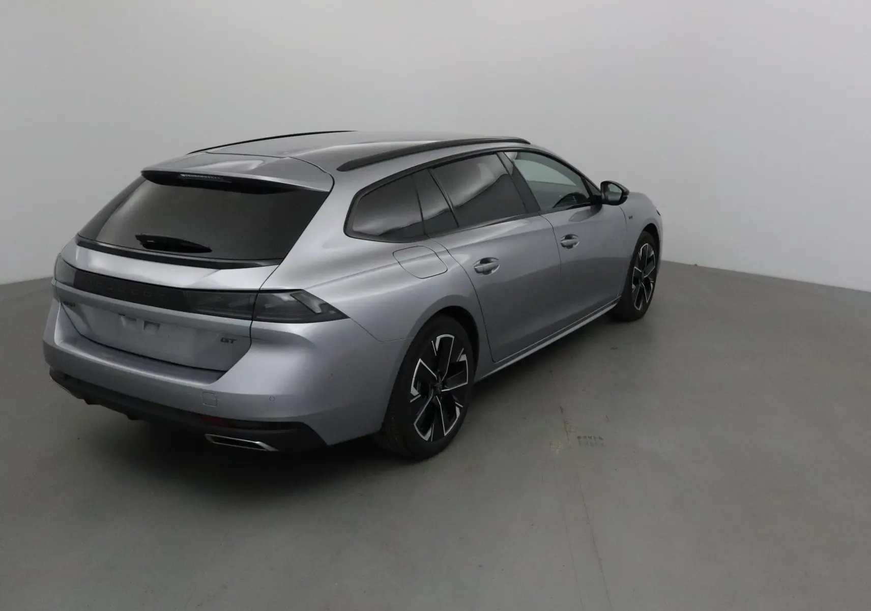 Peugeot 508 SW gris Artense vue 3/4 arrière droit, avec vitres teintées et jantes alliage noires.