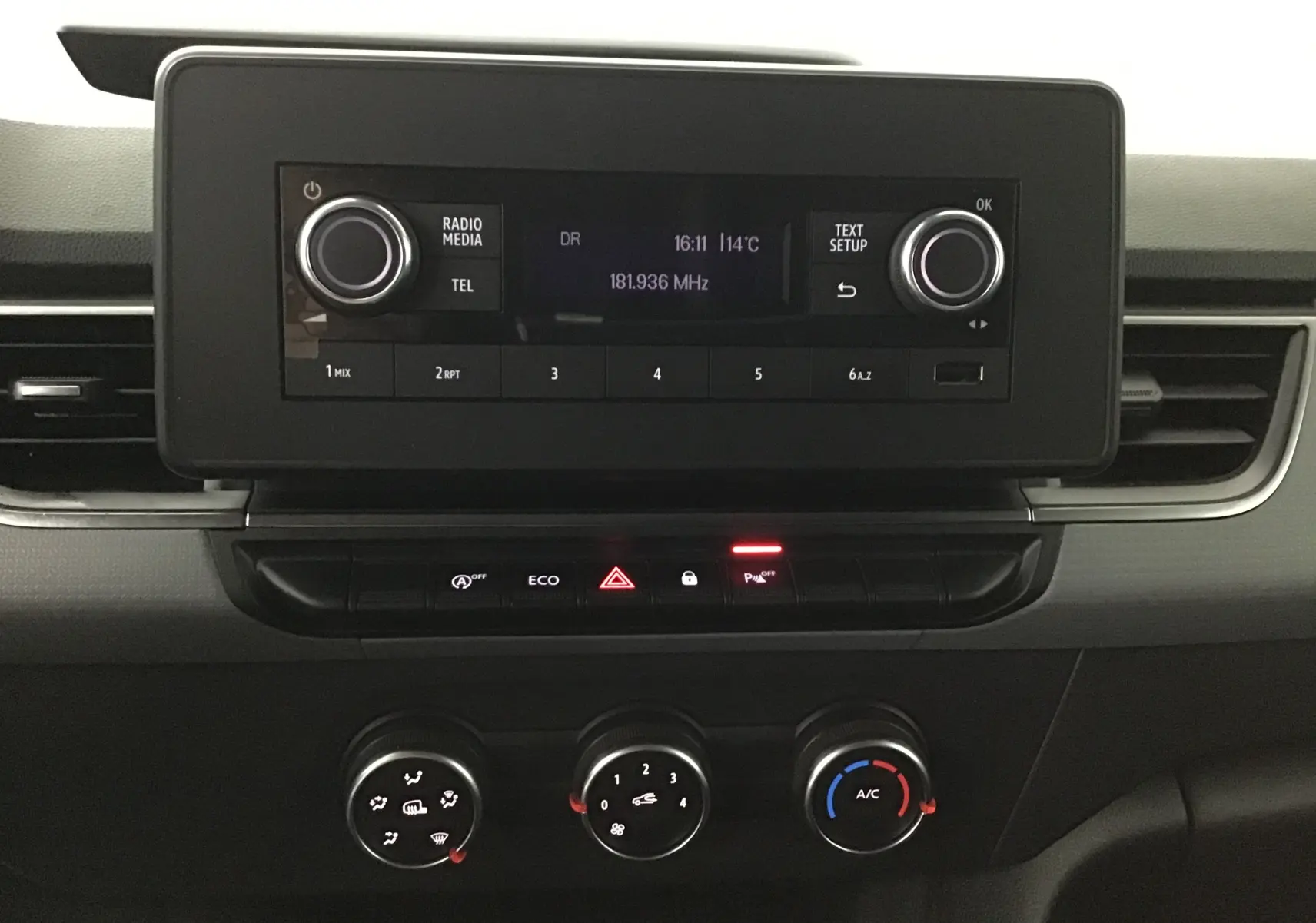 Tableau de bord du Renault Kangoo blanc 2022, vue frontale centrée sur la radio et les commandes de climatisation.