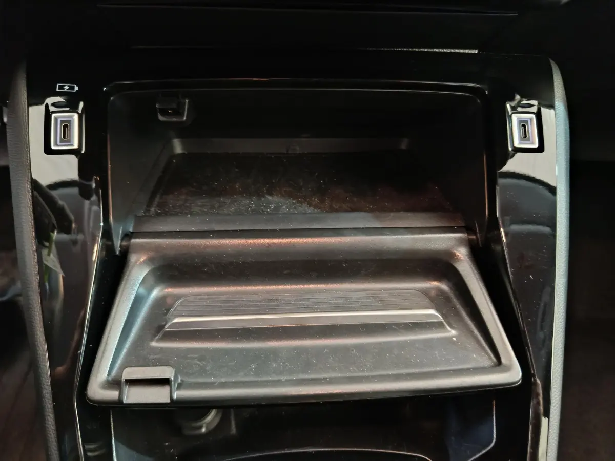 Rangement central ouvert avec ports USB visibles, intérieur noir brillant du Peugeot 208 PureTech 100 S&S Allure 2025.