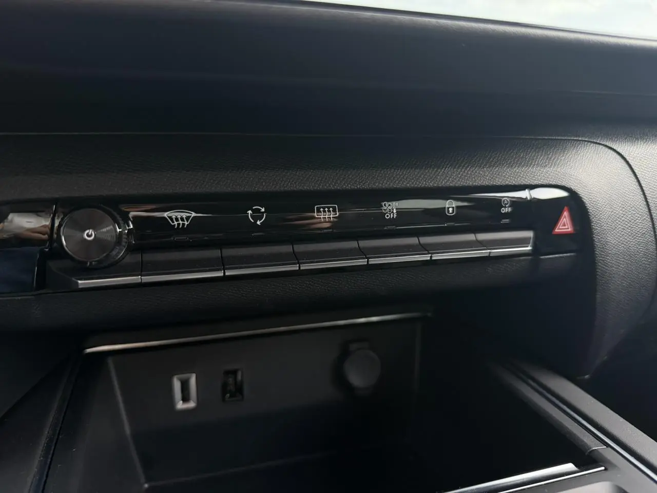 Vue rapprochée de la console centrale noire du Citroën C5 Aircross 2025 avec commandes climatisation et prises USB visibles.