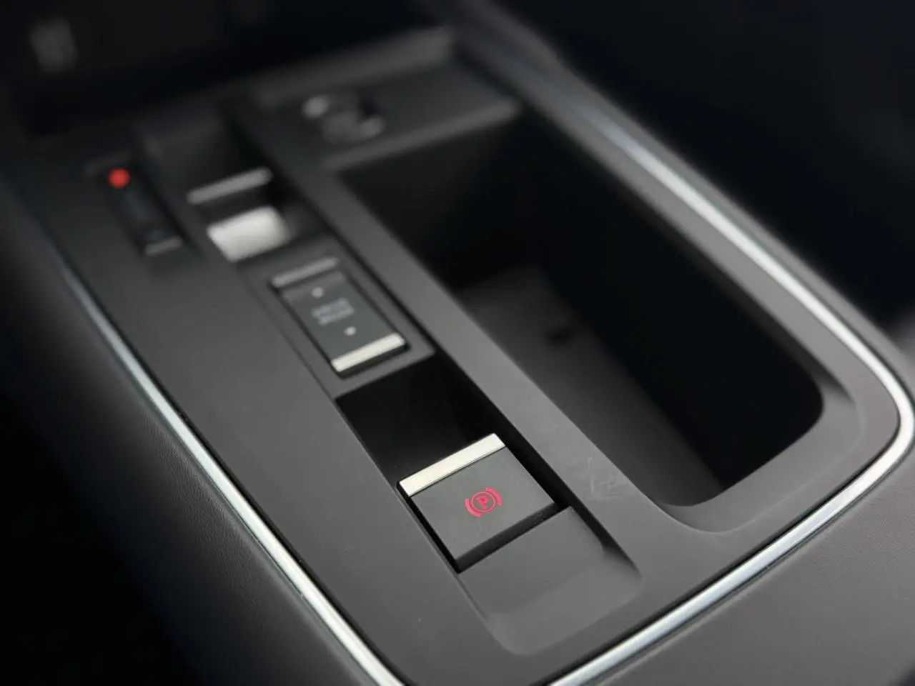 Gros plan sur la console centrale noire du Citroën C5 Aircross 2025, avec frein de stationnement électrique activé.