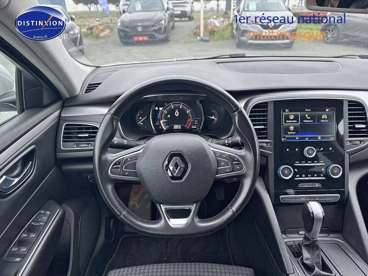 Vue intérieure centrée sur le volant cuir multifonction et l'écran tactile du tableau de bord d'une Renault Talisman 2020.