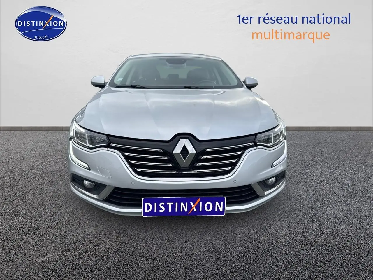 Vue frontale d'une Renault Talisman gris alu 2020 avec calandre noire et phares LED allumés.