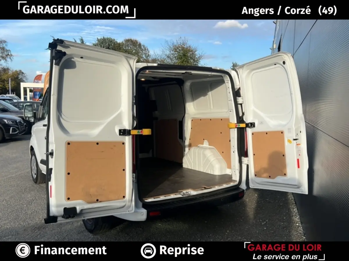 Vue arrière du Ford Transit Custom blanc 2023 avec portes arrière ouvertes montrant l’espace de chargement vide.