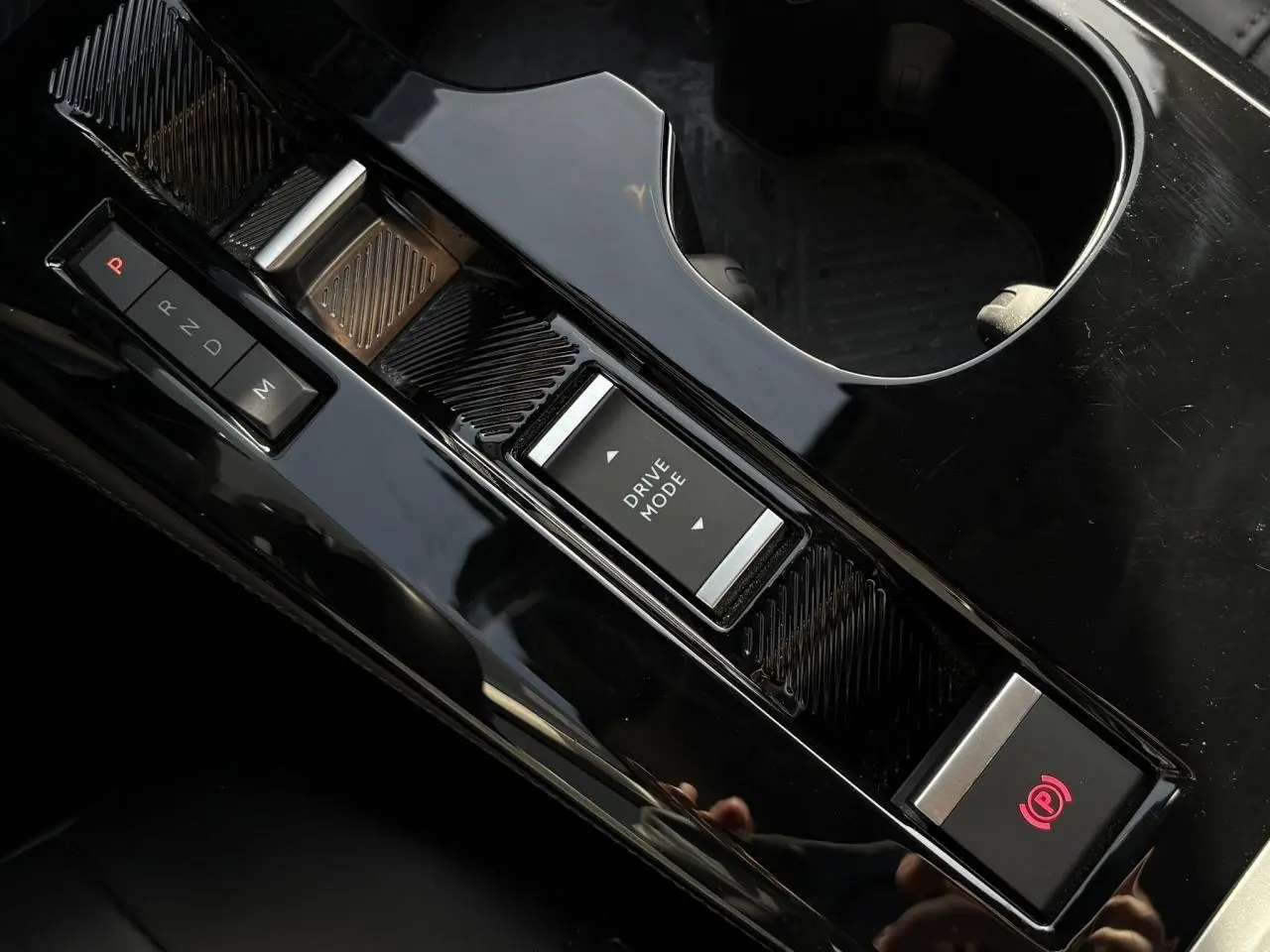 Gros plan sur la console centrale noire brillante du Citroën C5 X avec commandes boîte auto et mode de conduite.