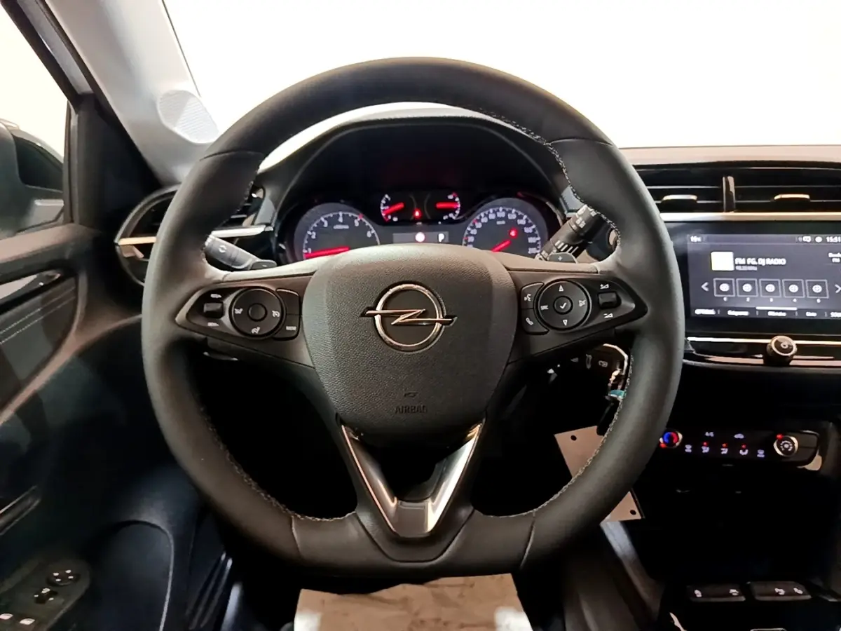 Vue intérieure centrée sur le volant cuir multifonctions et l'écran tactile 7 pouces de l'Opel Corsa 2023 blanc.