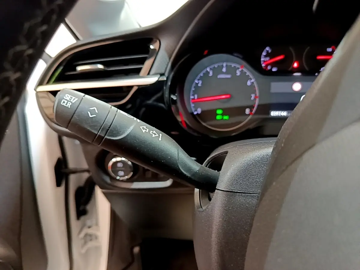 Gros plan sur la commande de clignotant et le tableau de bord éclairé d’une Opel Corsa blanche de 2023.