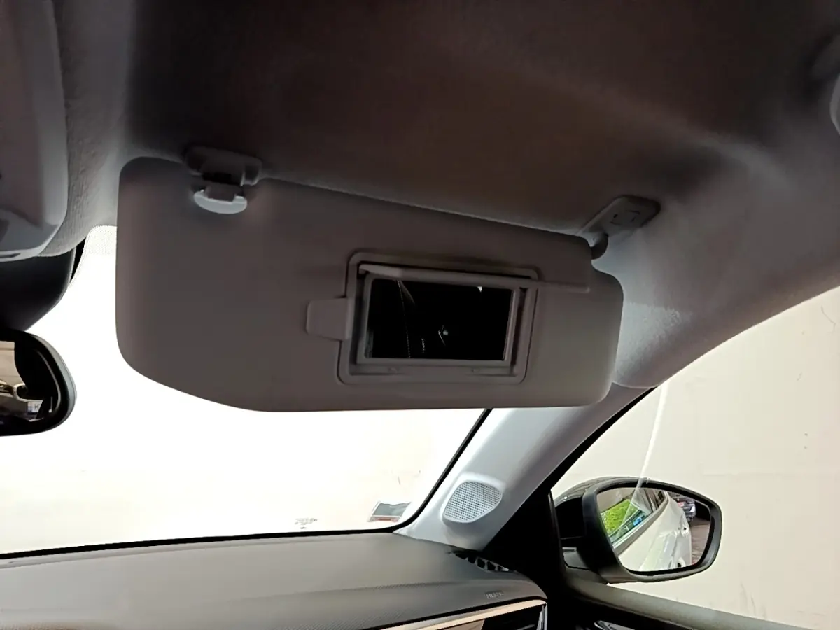 Détail intérieur montrant le pare-soleil avec miroir intégré côté conducteur d’une Opel Corsa blanche 2023.