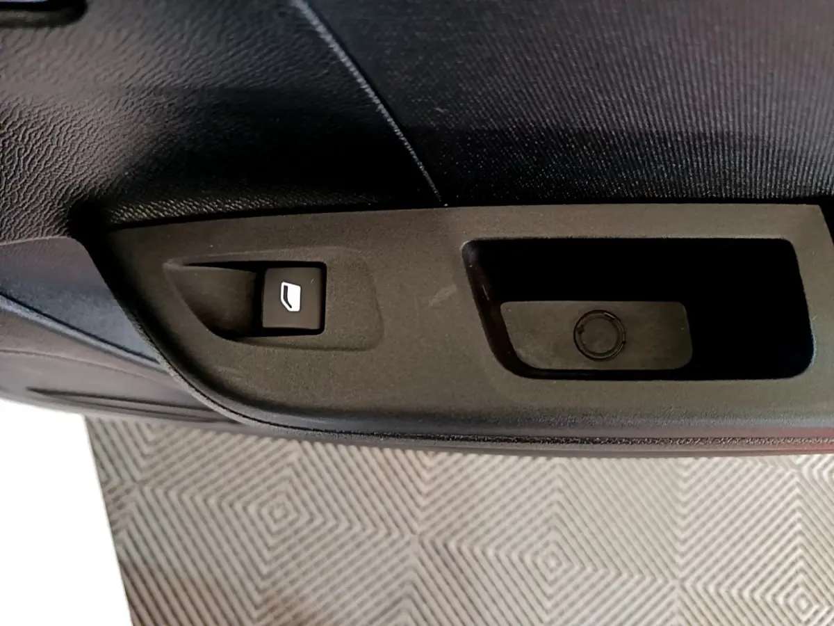 Détail de la commande de lève-vitre sur la porte intérieure côté conducteur d’une Opel Corsa blanche 2023.