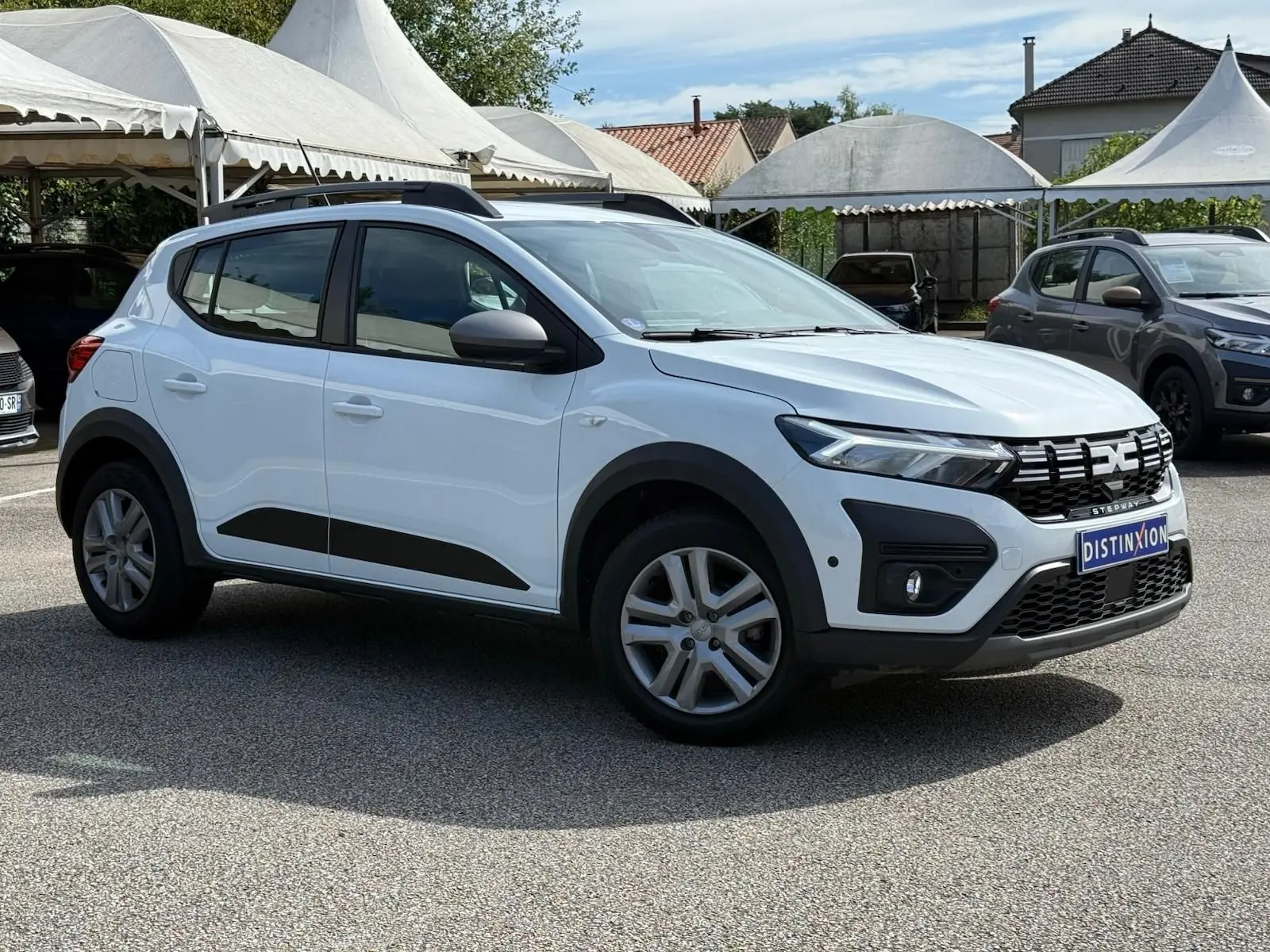 Vue 3/4 avant d'une Dacia Sandero blanche 2023 avec détails noirs et calandre distinctive Stepway.
