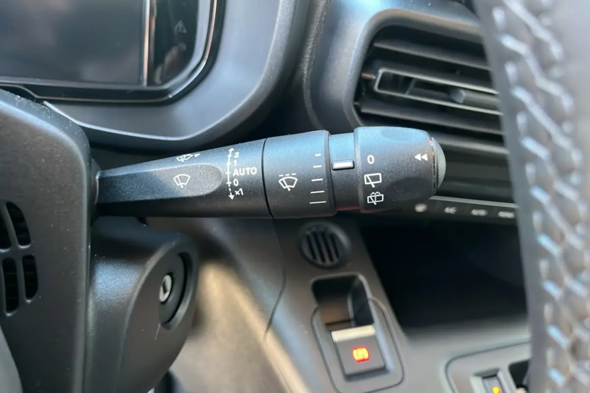 Gros plan sur la commande d’essuie-glace à gauche du volant cuir d’un Citroën Berlingo gris Artense 2025.