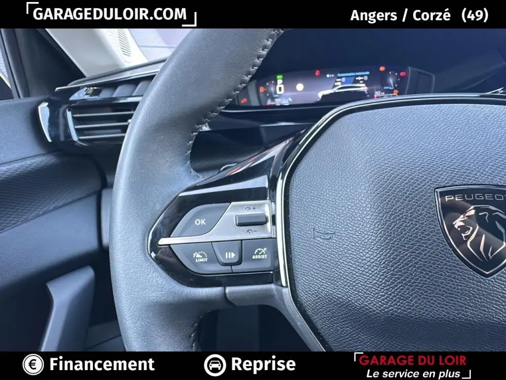 Gros plan sur le volant cuir noir de la Peugeot 308 2023, avec commandes multifonctions et tableau de bord numérique.