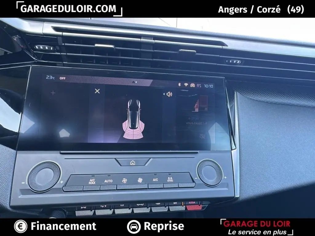 Vue rapprochée de l'écran tactile central et des commandes de climatisation du tableau de bord d'une Peugeot 308 gris clair 2023.