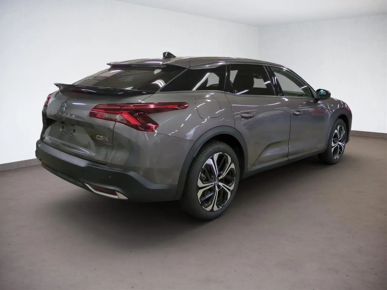 Vue 3/4 arrière droit d'une Citroën C5 X gris Platinium avec jantes alliage 19'' et feux arrière LED 3D.