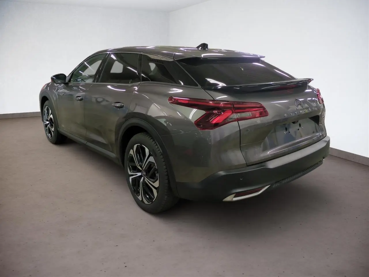 Vue 3/4 arrière droite d'une Citroën C5 X gris Platinium avec jantes alliage noires et feux arrière LED en V.