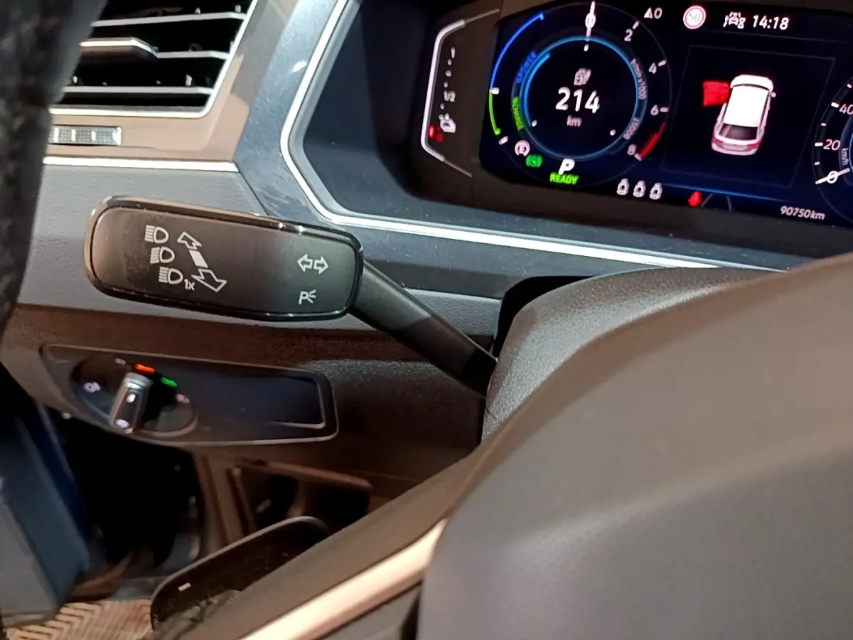 Gros plan intérieur sur le combiné d'instruments digital et la commande de clignotants du Volkswagen Tiguan bleu 1.4 eHybrid 2021.