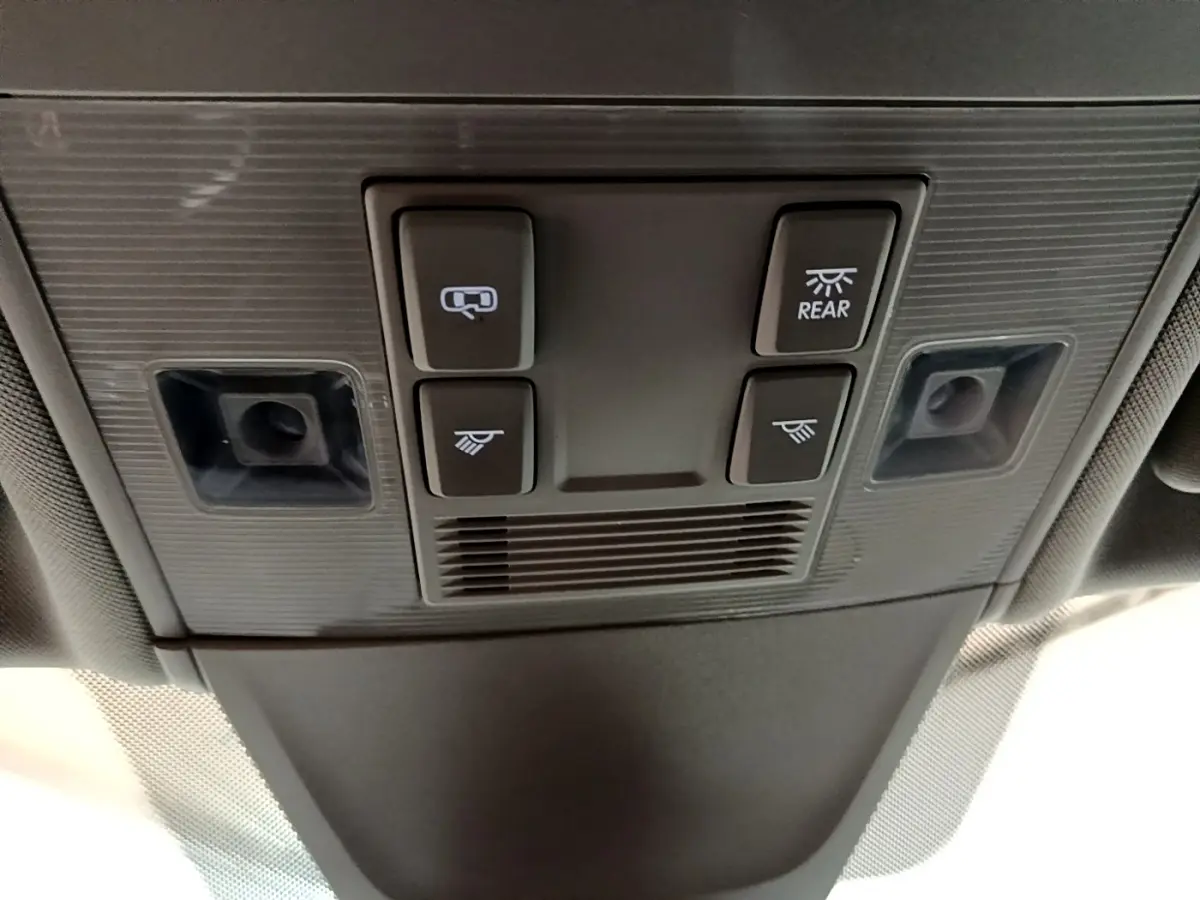 Gros plan sur la console de plafonnier avec commandes d’éclairage et capteurs dans un Volkswagen Tiguan bleu hybride rechargeable.