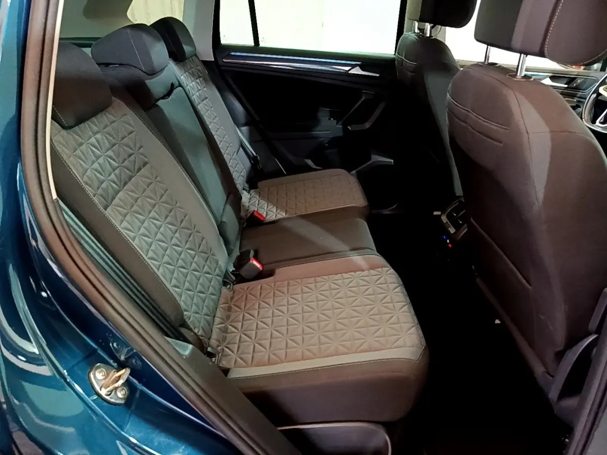 Vue intérieure côté gauche sur la banquette arrière grise avec motifs géométriques du Volkswagen Tiguan bleu 1.4 eHybrid 2021.