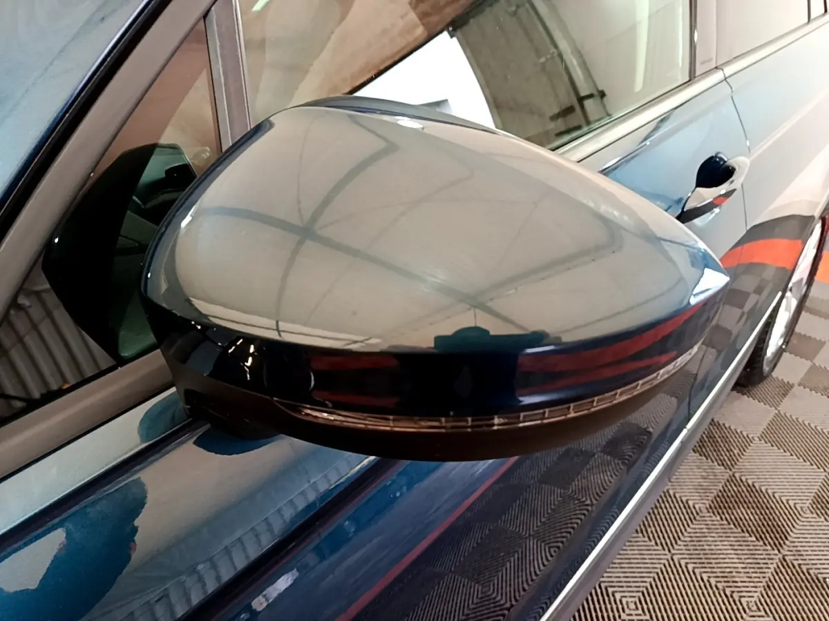 Gros plan sur le rétroviseur droit bleu du Volkswagen Tiguan 1.4 eHybrid 245 DSG6, avec clignotant intégré.