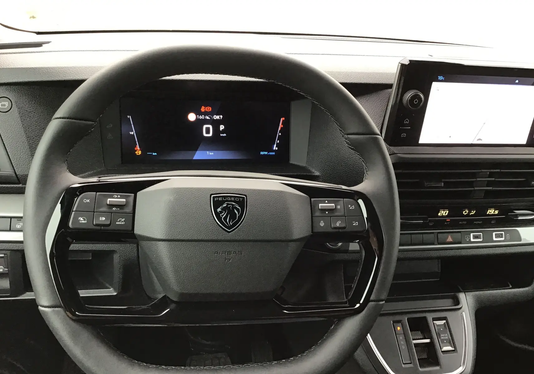 Vue intérieure centrée sur le volant noir du Peugeot Expert XL, avec tableau de bord numérique et écran tactile à droite.
