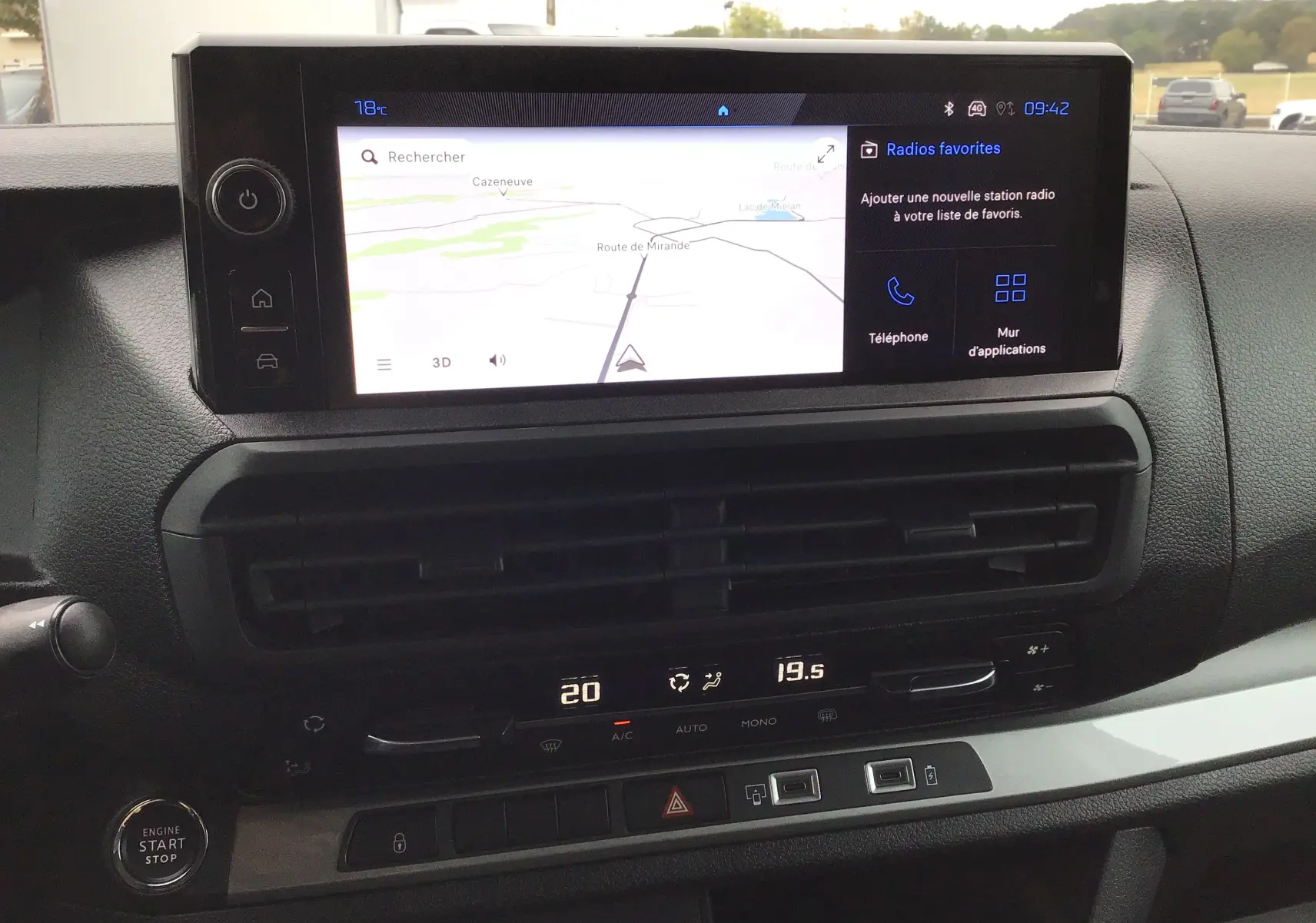 Vue rapprochée du tableau de bord du Peugeot Expert XL gris titane, avec écran tactile affichant la navigation et commandes climatisation.