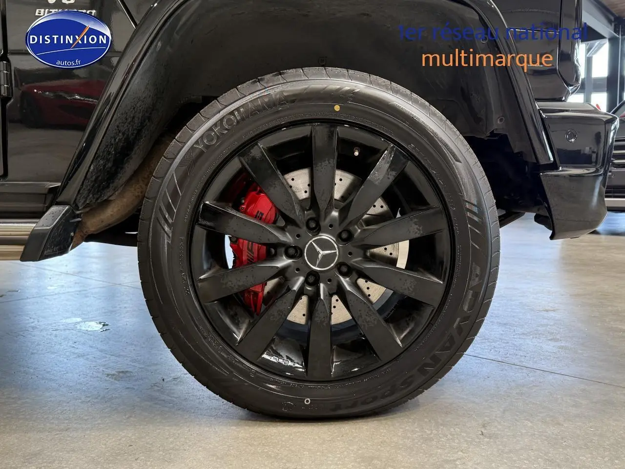 Gros plan sur la roue arrière gauche noire du Mercedes Classe G 5.5 63 AMG avec étrier de frein rouge visible.