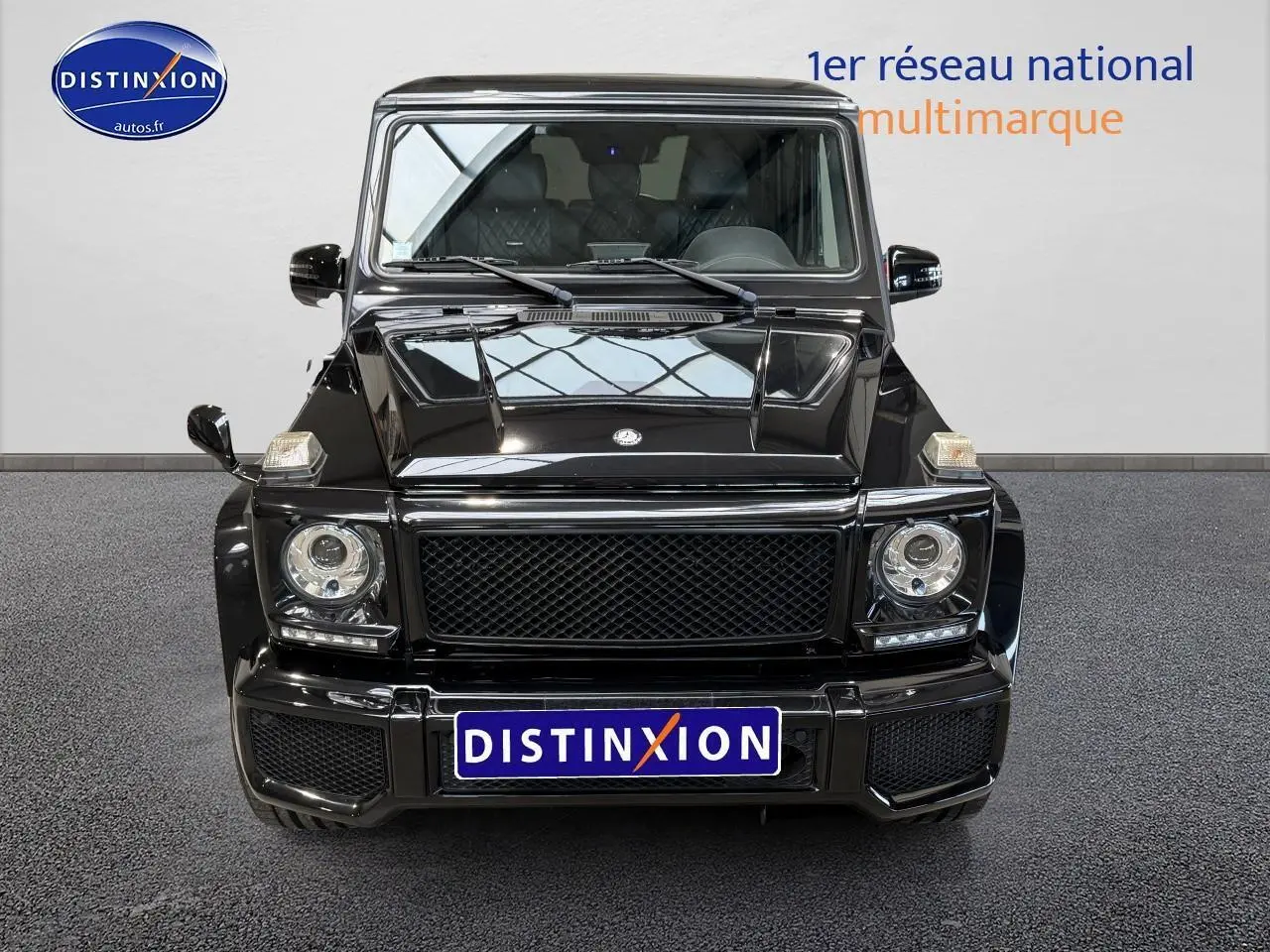 Vue frontale d'un Mercedes Classe G 5.5 63 AMG noir brillant avec calandre noire et phares ronds LED.