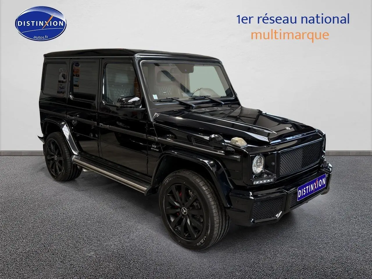Mercedes Classe G 5.5 63 AMG noir vu en 3/4 avant droit avec jantes noires et calandre distinctive noire.