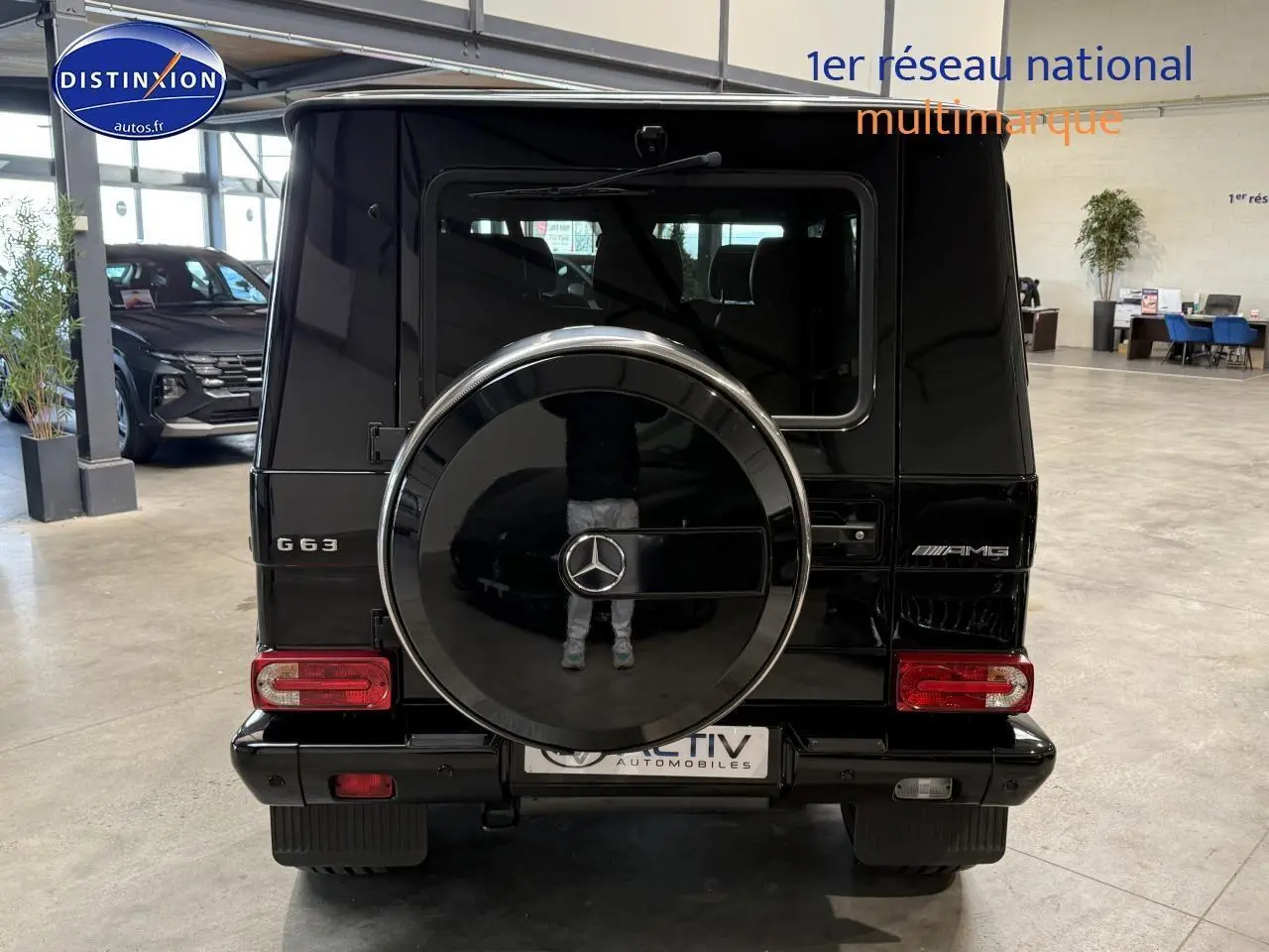 Vue arrière d'un Mercedes Classe G 63 AMG noir avec roue de secours intégrée et logo AMG visible.
