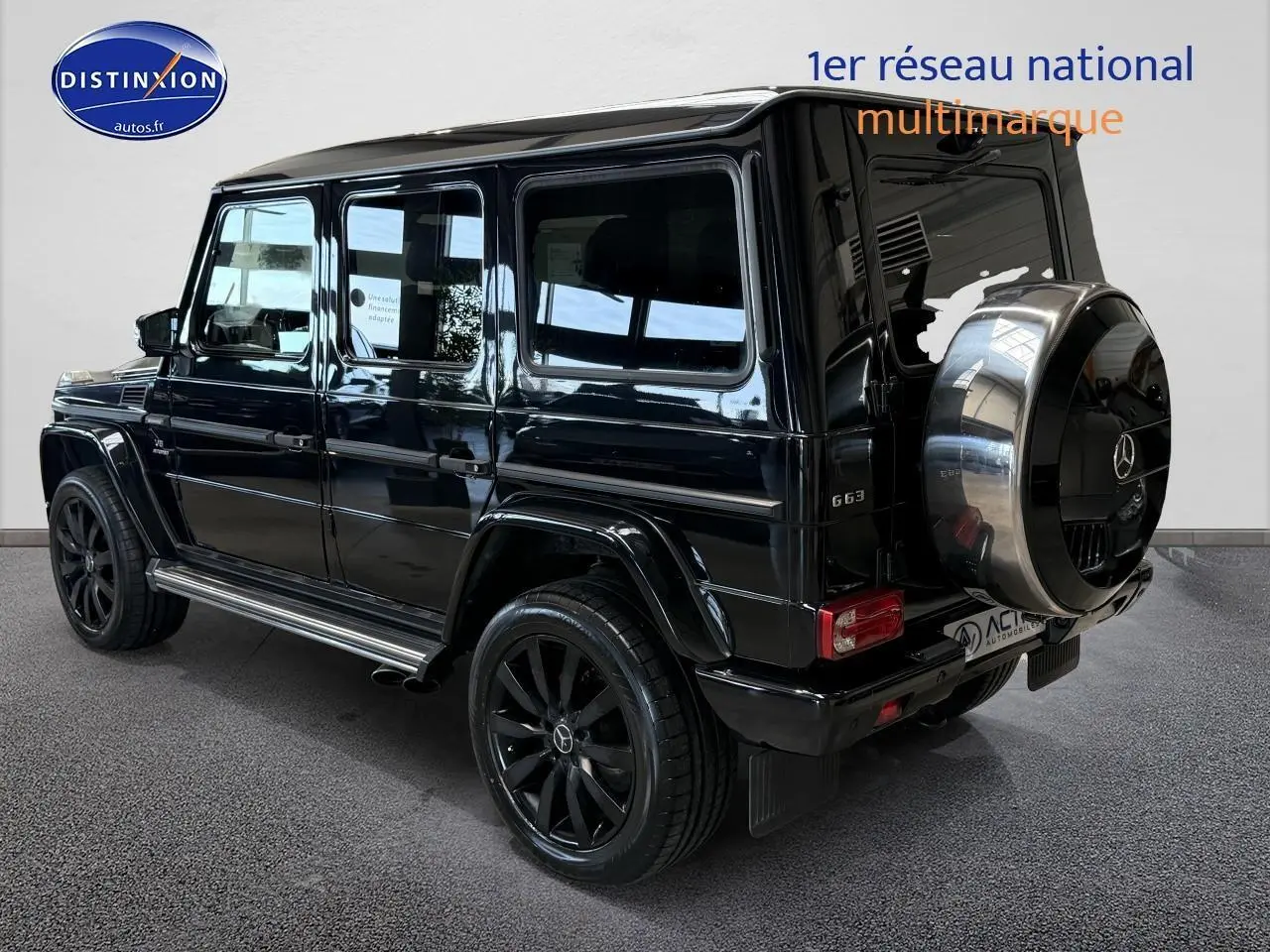 Mercedes Classe G 63 AMG noir vue 3/4 arrière droit avec roue de secours chromée et jantes noires.