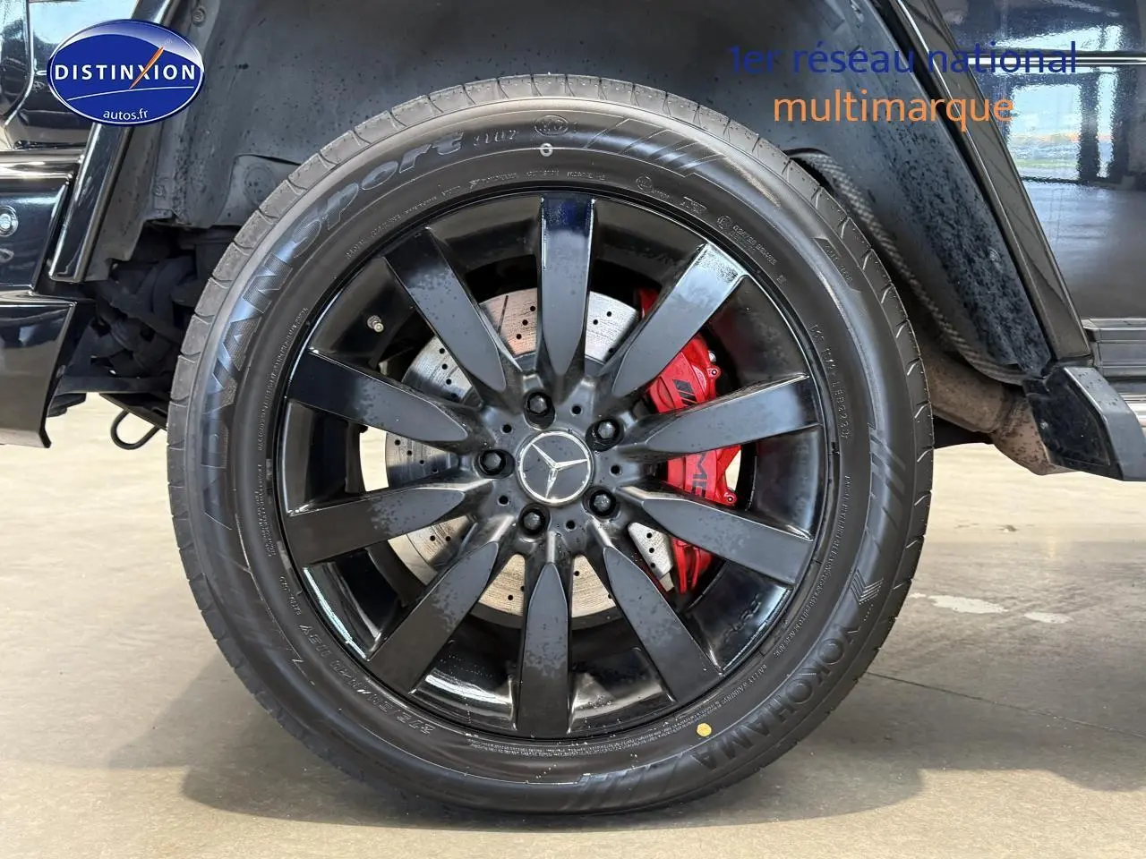 Gros plan sur la jante noire et l'étrier de frein rouge du côté gauche d'un Mercedes Classe G 5.5 63 AMG noir.