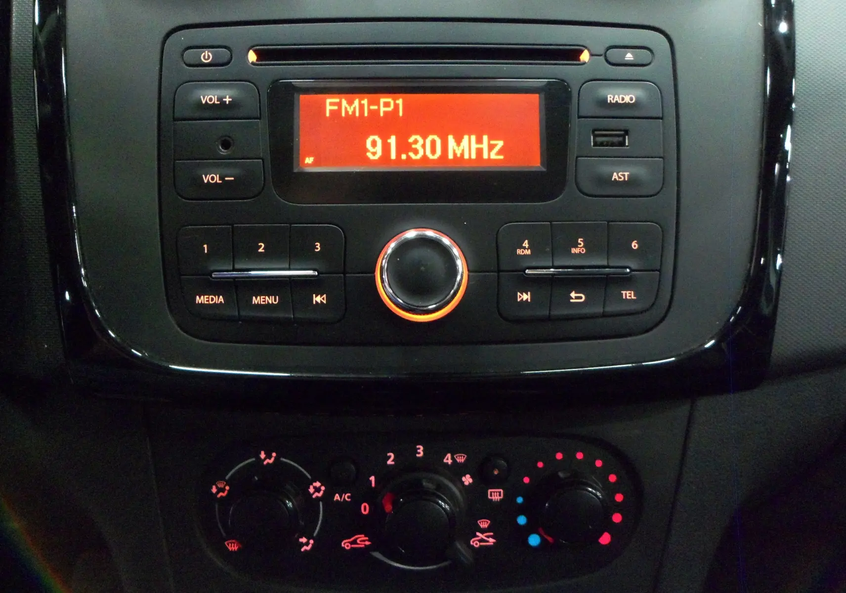 Gros plan sur la console centrale noire de la Dacia Sandero Stepway 2016, avec radio et commandes de climatisation éclairées.
