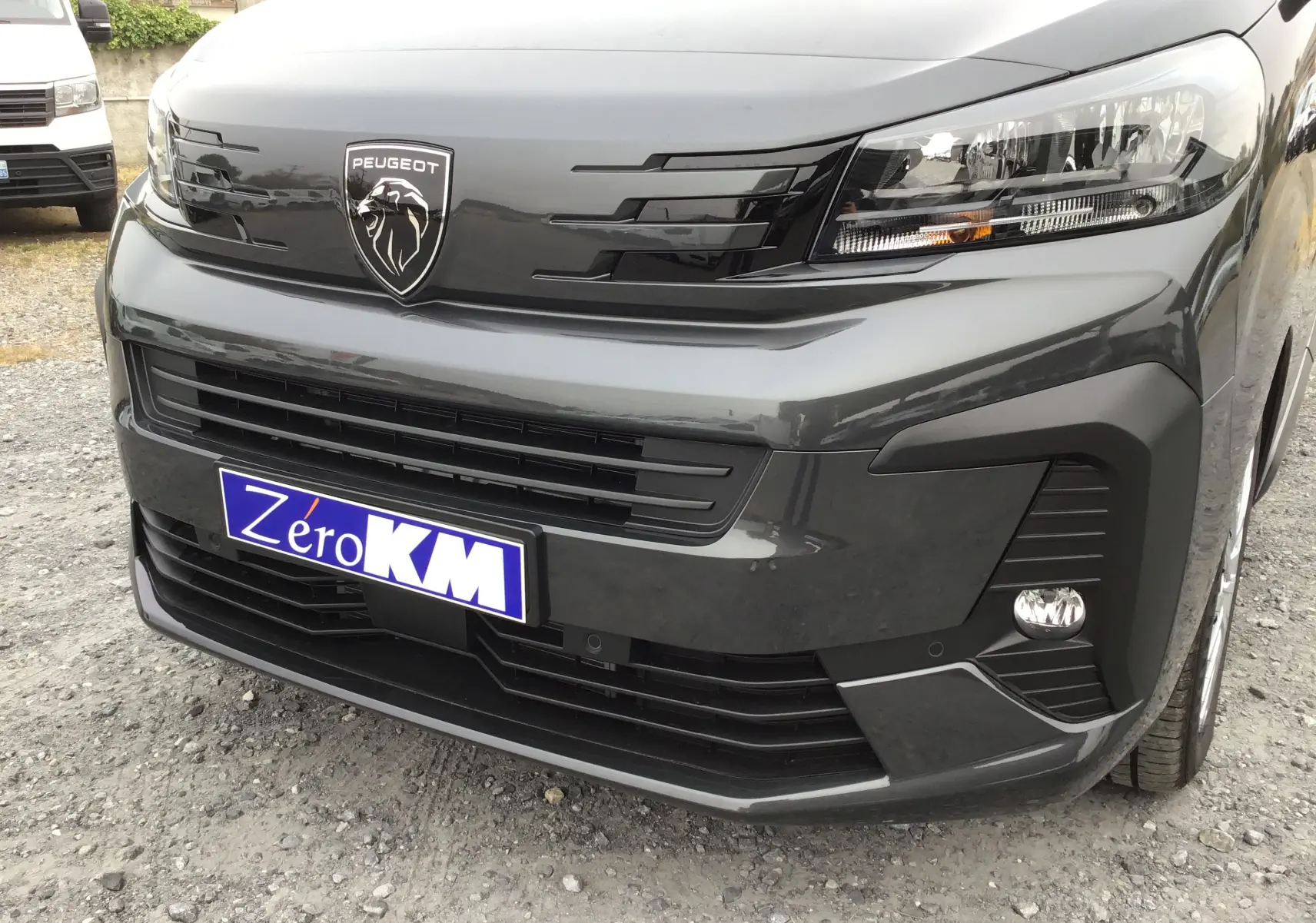 Vue rapprochée 3/4 avant droit du Peugeot Expert Cabine Approfondie gris titane avec logo lion et calandre noire.