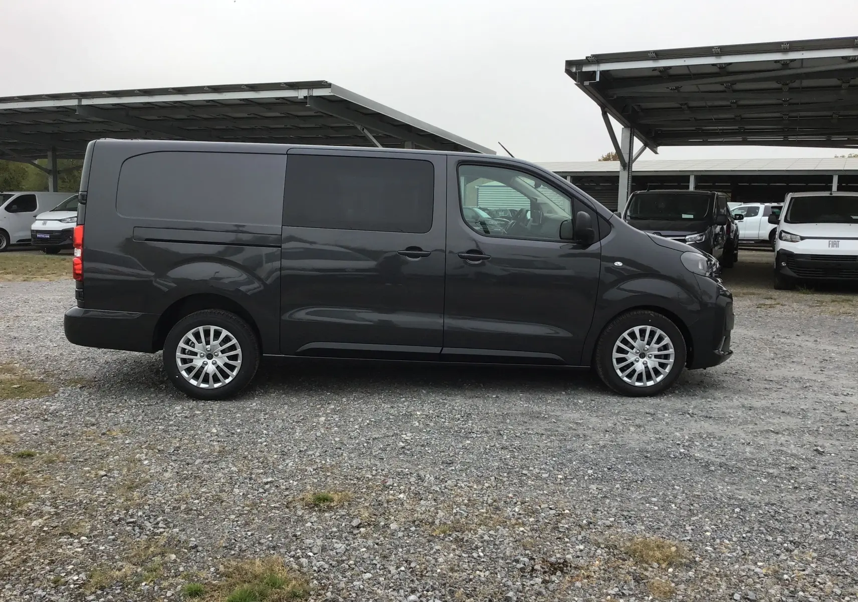 Vue de profil côté gauche d’un Peugeot Expert cabine approfondie gris titane, avec jantes alliage et vitres teintées arrière.