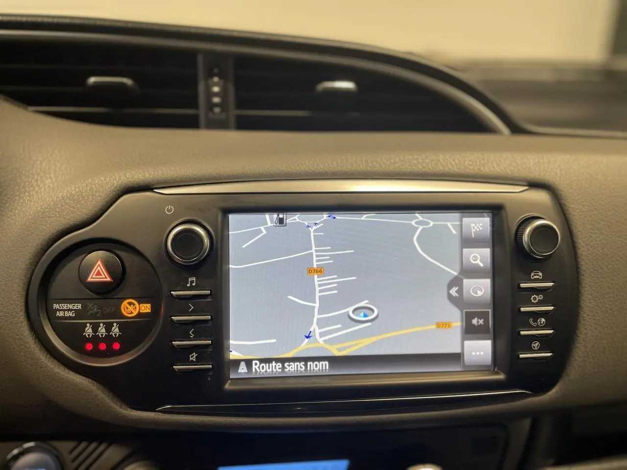 Écran tactile du système de navigation Toyota Touch & Go 2 sur tableau de bord noir de Yaris hybride gris foncé.