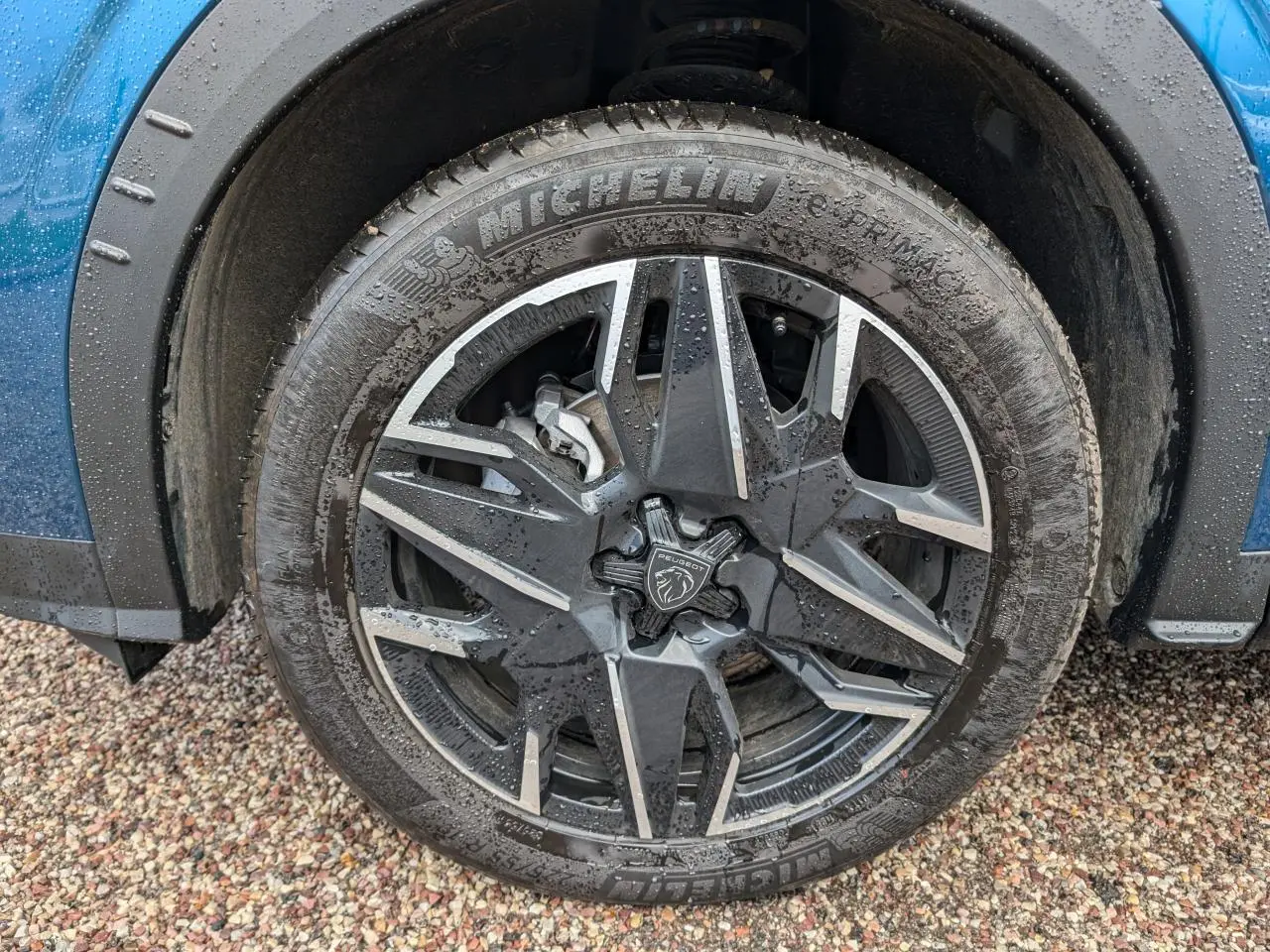 Gros plan sur la jante alliage 19'' diamantée noire du côté avant gauche d’un Peugeot 3008 bleu métallisé.