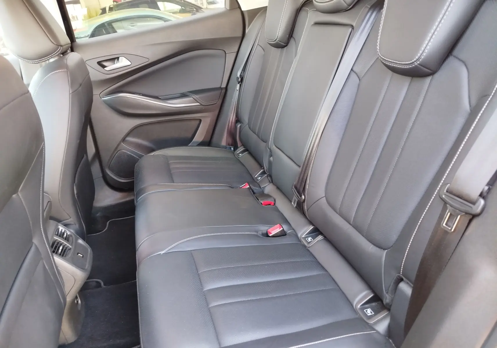 Vue intérieure côté droit des sièges arrière en cuir noir avec surpiqûres blanches de l'Opel Grandland X 2021.